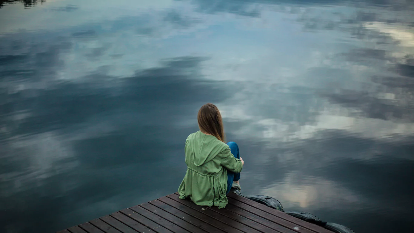 Stress & Anxiety 1 Woman sitting by lake with anxiety